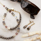 Necklace and earrings with sunglasses on a marble surface