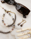 Necklace and earrings with sunglasses on a marble surface