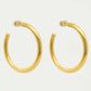 Gold hoop earrings on a light gray background