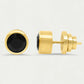 Gold earrings with black gemstones on a light gray background