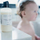 Baby wash bottle on a surface with a blurred child in the background