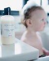 Baby wash bottle on a surface with a blurred child in the background
