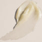 Close-up of a smooth, beige-colored cream on a light beige background