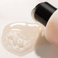 Close-up of a skincare product with a black cap on a light background