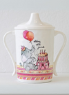 Children's sippy cup with elephant and cake design on a white background