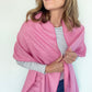 Woman wearing a pink scarf with a white background