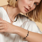 Model wearing the GeoCUBE fusion collection in  pearl, black and onyx. Featuring earrings, a necklace and a bracelet.