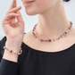 Model wearing the GeoCUBE collection in lilac featuring a necklace, earrings and a bracelet.