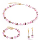 View of the geoCUBE mono pink collection featuring a necklace, earrings and a bracelet