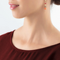Model wearing the red and gold GeoCUBE earrings wearing a dark red shirt