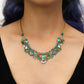 Close-up of a person wearing a decorative necklace with green and blue stones.