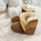Side view of a pair of chestnut coloured booties with a cosy lining and a velcro closure