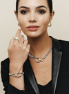 A model posing with silver and gold jewelry in a black blazer