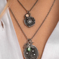 Close-up of layered necklaces with intricate pendants on a white background