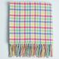 Colourful tartanblanket with tassels on a light gray background