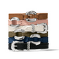 View of a stack of leather bracelets with a silver circular embellishment and buckle