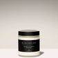 Jar of body crème with black lid and label on a light background