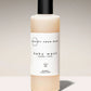 Baby wash bottle with a black cap and white label on a beige background