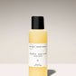 Baby serum bottle with black cap and white label on a light gray background
