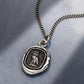 Silver necklace with a pendant on a gray surface